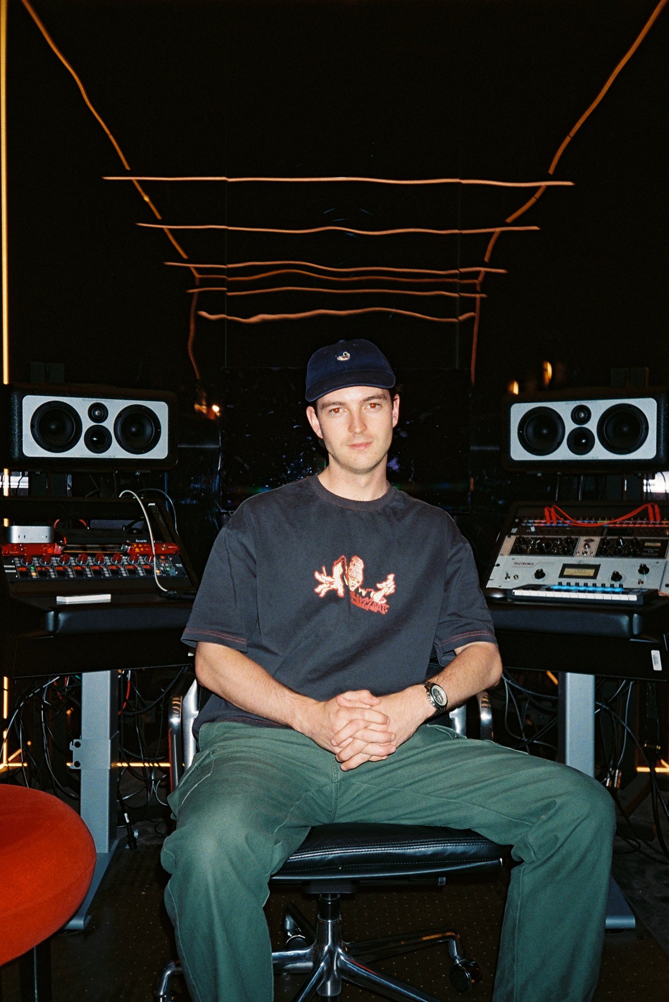 Tom (Wax Thief) sitting in a production room, studio monitors and outboard gear behind him